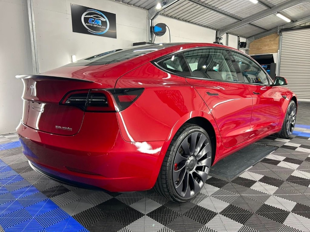 Red Tesla Model 3 rear quarter after a ceramic coating