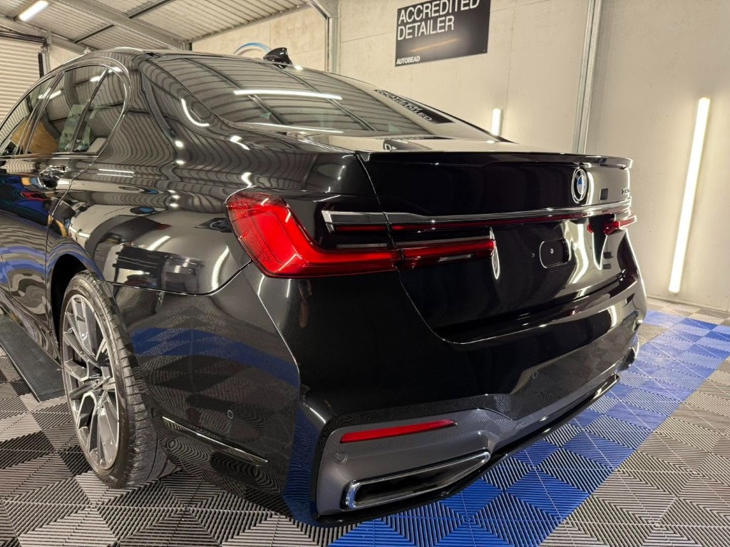 Black BMW 7 Series rear quarter with a deep gloss finish